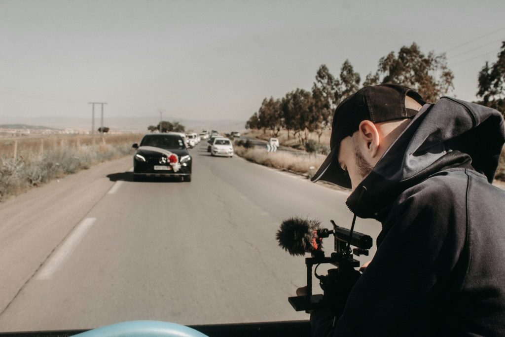 man filming a car